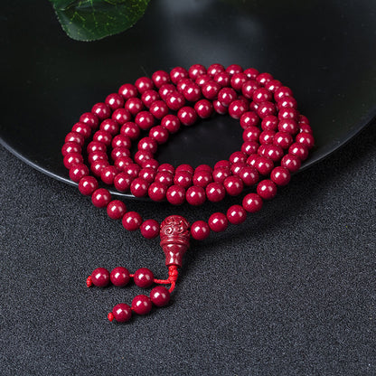 Close - up of the carved pendant on the 108 - bead cinnabar bracelet reveals intricate patterns, a showcase of ancient artistry.