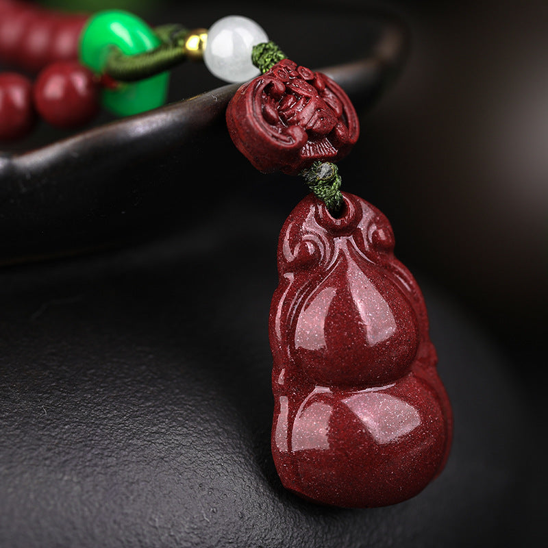 Close - up view of the cinnabar gourd pendant and the carved cinnabar ornament above it Revealing the fine - tuned craftsmanship.