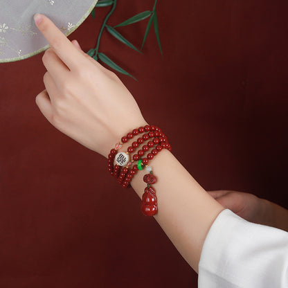 The 108 - bead cinnabar jewelry worn as a bracelet on a wrist Presenting a seamless blend of beads and the gourd - shaped pendant.