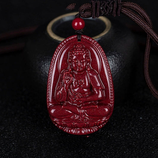 A cinnabar pendant with a carving of a Bodhisattva, hanging beside a black pot. The deep - red cinnabar shows a beautiful luster.